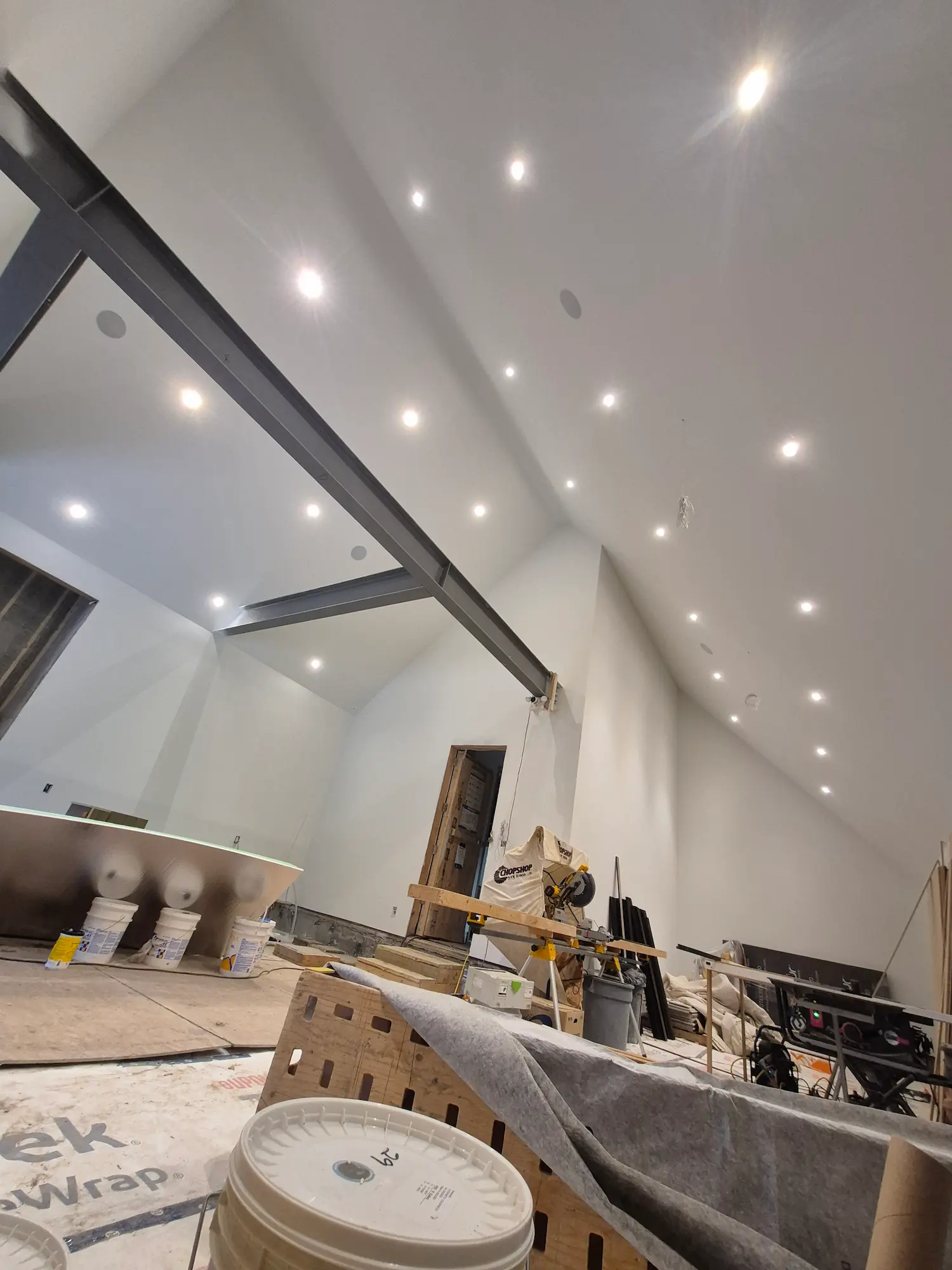 Interior of a room under construction with drywall installed and seams taped but not yet painted.